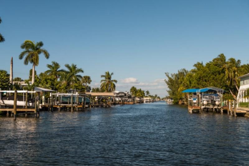 Boat docks along a palm-lined Cape Coral canal